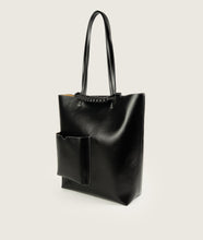 Load image into Gallery viewer, Pazar I Pazar Book Tote Grape Leather I Black with white Stitching I side view I showing the iconic closure system and the outside book pocket I also showing the even more stable straps I white background